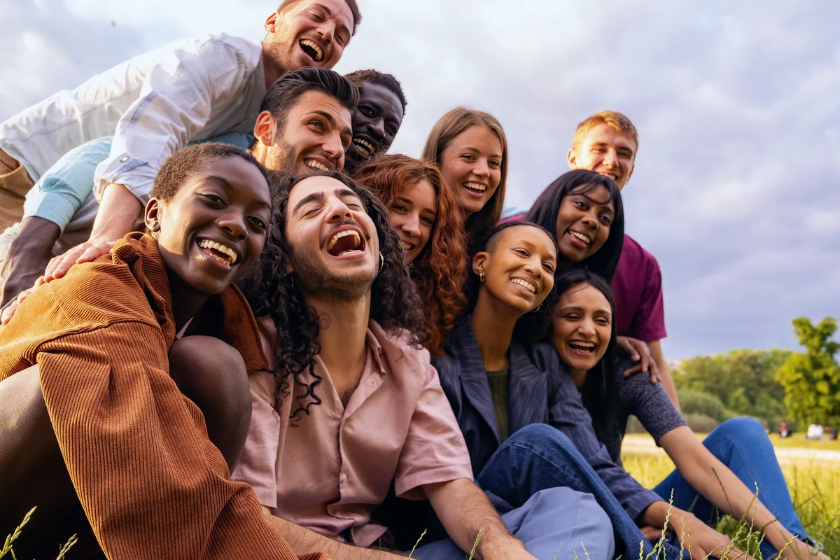 Large diverse group of friends laughing together outdoors