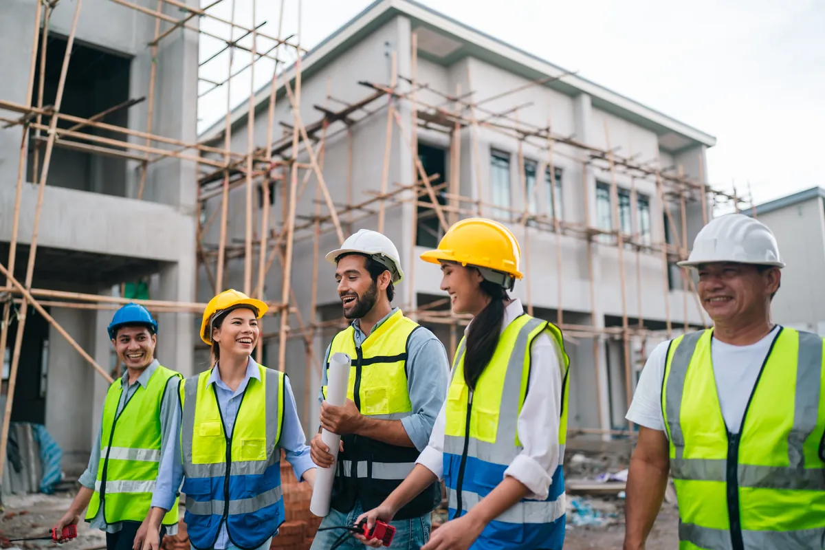 Diverse team of engineers in hard hats and hi-vis vests on a building site