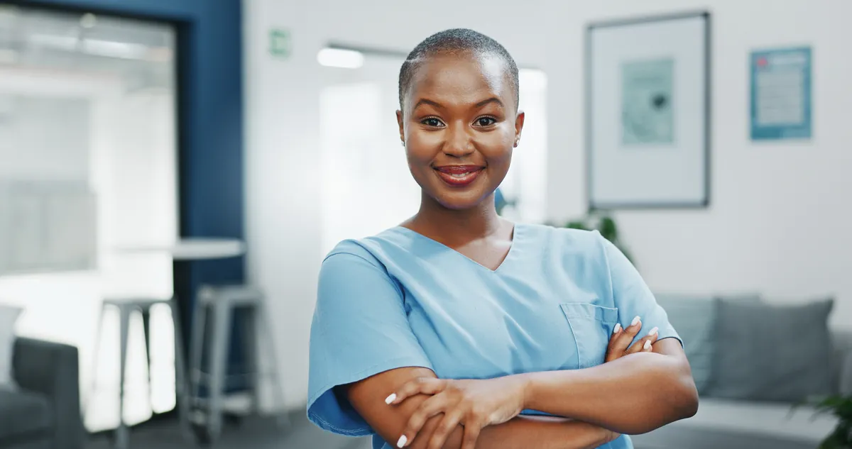 Confident nurse in blue scrubs smiling in a bright clinic