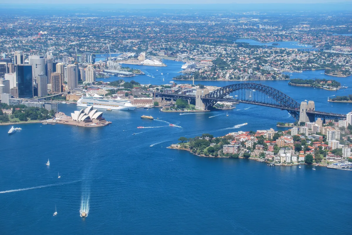 Aerial view of Sydney Harbour with the Opera House and Harbour Bridge in bright sun